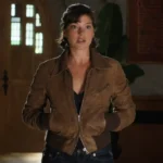 A woman wearing a brown leather jacket styled with a soft inner lining and modern fit, inspired by a TV series character outfit.