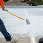man waterproofing a building