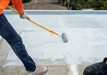 man waterproofing a building
